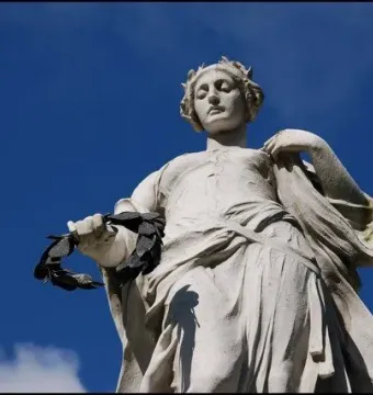 Titanic Memorial statue of a woman holding a laurel wreath against a blue sky