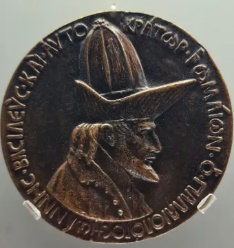 Medal of John VIII Palaiologos showing a bearded profile bust with a tall pointed hat and Greek inscription around the edge.
