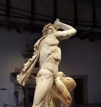 Ludovisi Gaul marble sculpture showing a man raising a sword above his head beside a collapsing draped woman on a circular base.