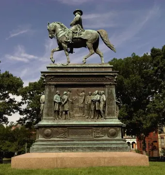 The Major General John A. Logan bronze equestrian statue on a tall pedestal in a park, with trees and buildings in the background.
