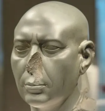 Berlin Green Head sculpture of a bald face with closed eyes and a damaged nose.