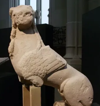Sphinx of Agost stone sculpture with a human head, wings, and an animal body on a base.