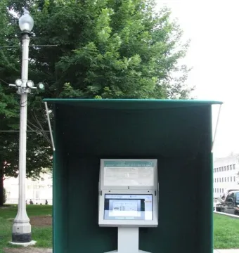 Burnham Pavilions canopy sheltering an interactive touchscreen kiosk on a concrete plaza.