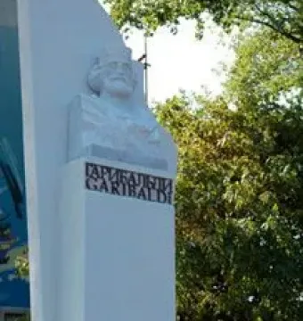 Garibaldi Monument with a bearded bust and floral tribute at the base