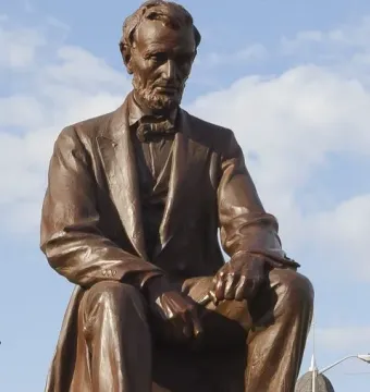 Bronze Lincoln Monument sculpture of a seated bearded man in a suit and bow tie.