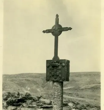 The Padrão de Santa Maria stone pillar with a crowned shield and cross on top, standing in a barren landscape.