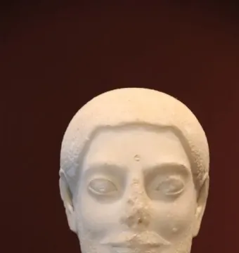 Sabouroff Head marble bust of a male figure with textured hair, mustache, and beard on a stand.
