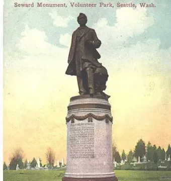 William Henry Seward monument in Volunteer Park, with a bronze statue on a tall stone pedestal in a grassy area.