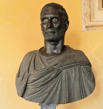 Capitoline Brutus bust with a dark patina, short hair, and a draped garment on a stand.