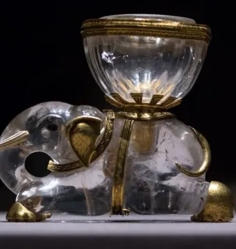 Crystal elephant with gold accents carrying a clear salt cellar on its back.