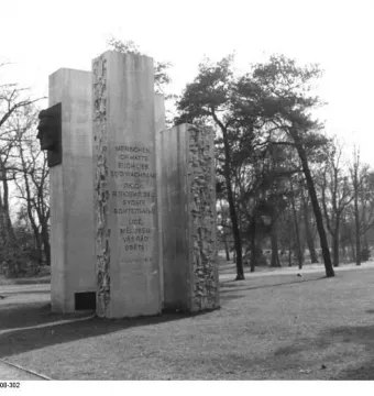 Julius Fučík Memorial with tall steles, a dark profile bust, and an inscribed panel in a park setting.