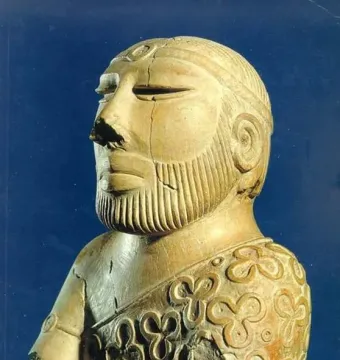Bust of the Priest-King showing a bearded man in profile with carved facial hair and a patterned cloak.