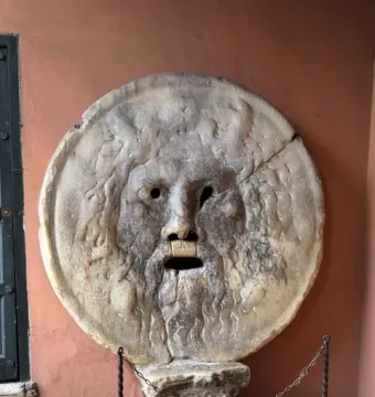 Bocca della Verità stone face with a wide open mouth and weathered surface