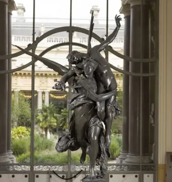 Gloria Victis bronze sculpture of a winged female figure carrying a fallen male warrior on a pedestal.
