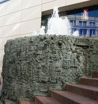 San Francisco Fountain with water spraying from a dark metallic sculptural structure beside brick steps.