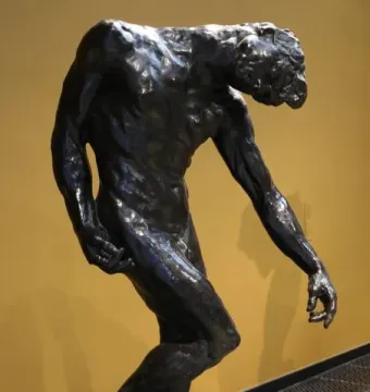 The Three Shades bronze sculpture by Auguste Rodin, showing a bowed figure on a rocky base.
