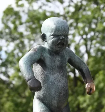 Angry Boy bronze statue of an upset toddler with clenched fists and a furrowed expression.