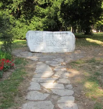 Keys Handover Memorial stone monument with Cyrillic inscription and bas-relief figures in a park