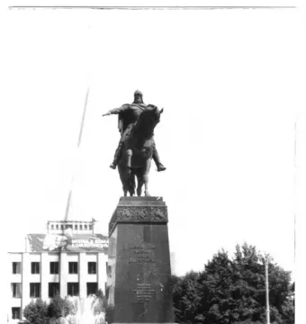 The Monument to Yuri Dolgorukiy, an equestrian statue on a tall pedestal, with trees and a fountain in the background.