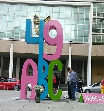 Antimonumento 49 ABC standing on a city plaza, with a pink \