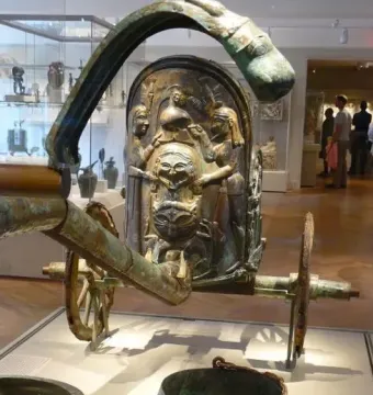 Monteleone Chariot bronze chariot with relief decorations and a stylized face on display in a museum