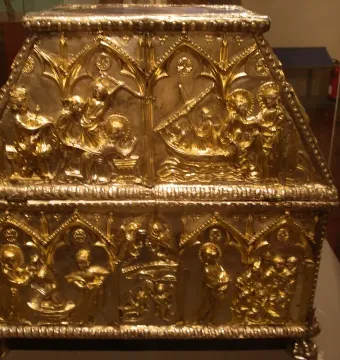Sant Cugat Casket with a sloped lid, covered in intricate embossed scenes and small figures within arched panels.
