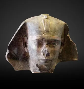 Damaged stone head of Djedefre sphinx with a royal headdress and missing nose