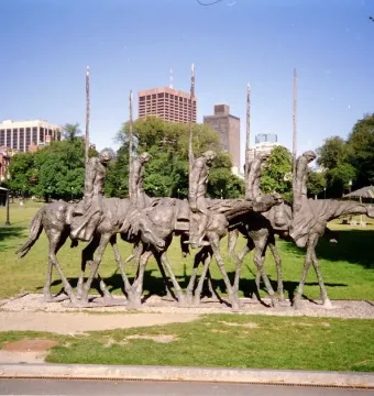 The Partisans sculpture shows several gaunt figures riding skeletal horses and holding tall poles in a grassy urban park.