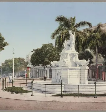 Fuente de la India fountain with a seated female statue and dolphin sculptures in a street median