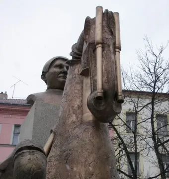 Close-up of the Statue of Jaroslav Hašek showing a metal horse head sculpture with a man’s bust behind it.