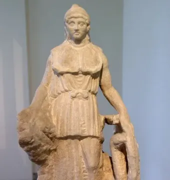 Unfinished marble Lenormant Athena statue with a helmet and long tunic, holding a large coiled object.