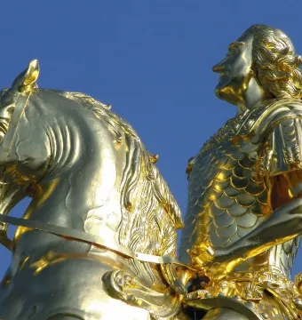 The Golden Rider equestrian statue in Dresden, showing a gilded man on a rearing horse against a blue sky.