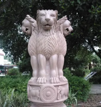 Lion Capital of Ashoka with three lions standing back-to-back above a carved drum and bell-shaped base.