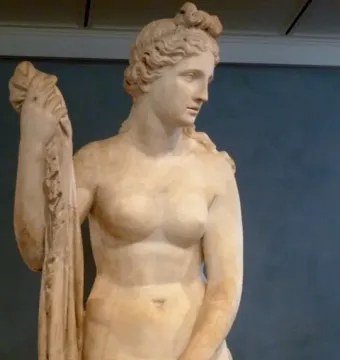 Mazarin Venus, a pale stone statue of a female figure holding draped fabric with braided hair.