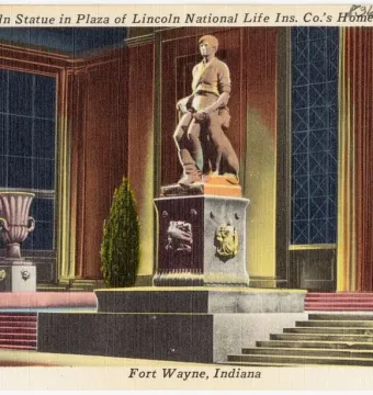 Abraham Lincoln: The Hoosier Youth bronze statue of a seated young Lincoln holding a book, with an axe and a dog beside him.