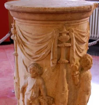 The Four Seasons Altar, a cylindrical stone altar with relief carvings of draped fabric, vessels, and child-like figures.