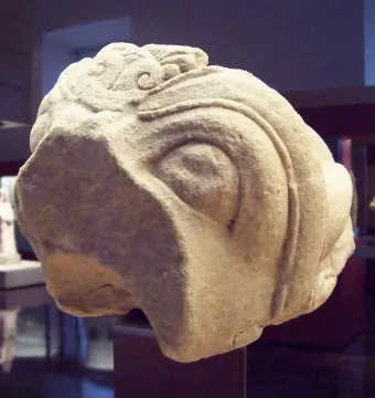 Grifo de Redován stone sculpture with a carved eye and ornate swirling details.