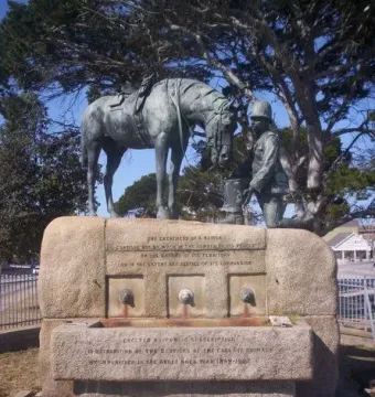 Horse Memorial with a dark metal horse statue and kneeling soldier on a granite base