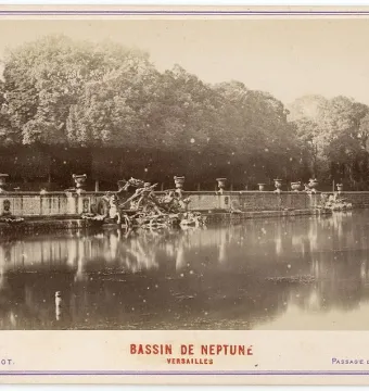 The Neptune Fountain beside a wide ornamental basin, with sculpted figures and creatures along the far wall