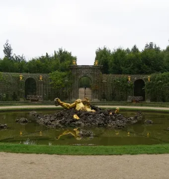The Enceladus Fountain shows a golden reclining figure emerging from dark rocks in a formal garden pond.