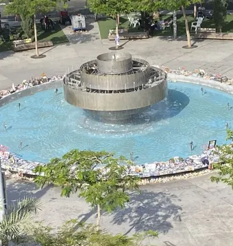 Top-down view of the Fire and Water Fountain with a circular basin, a tiered central structure, and small jets spraying water.
