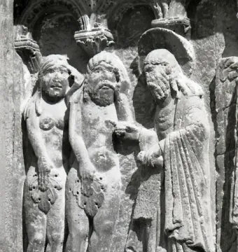 Stone relief of three figures, with two nude figures covering themselves with leaves and a robed figure gesturing toward them.