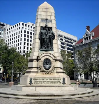 Stephenson Memorial with bronze figures of two men in military uniforms holding a flag above a circular medallion on a tiered stone base.