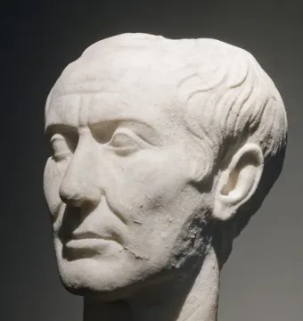 Tusculum portrait of Julius Caesar in weathered white marble, showing a stern face and receding wavy hair.