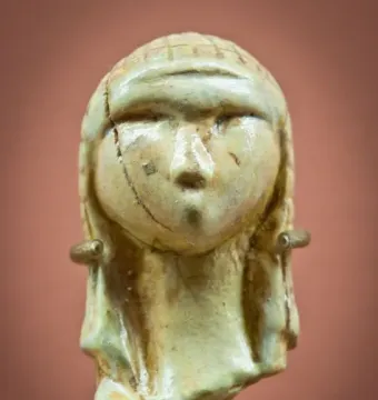Venus of Brassempouy carved head with a textured cap and cracked surface