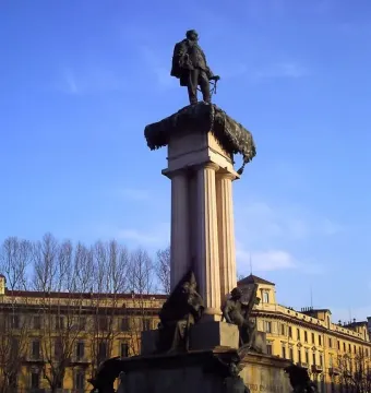 Monument to Vittorio Emanuele II with a bronze statue atop a fluted column and sculpted figures at the base.