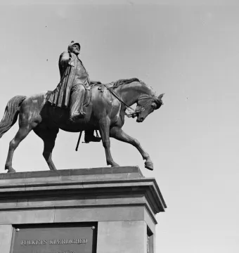 The equestrian statue of Christian V stands on a stone pedestal against a clear sky.