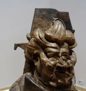 L\'antigrazioso, a bronze-toned abstract bust with angular fragmented forms and a distorted face.