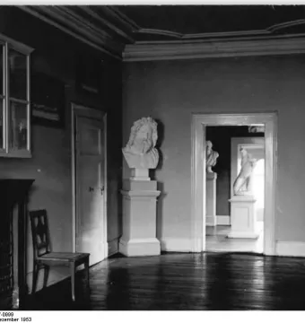 Marble head of Antinous Mondragone on a tall pedestal in a room with other classical sculptures.