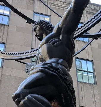 Atlas statue kneeling and holding a large curved structure at Rockefeller Center